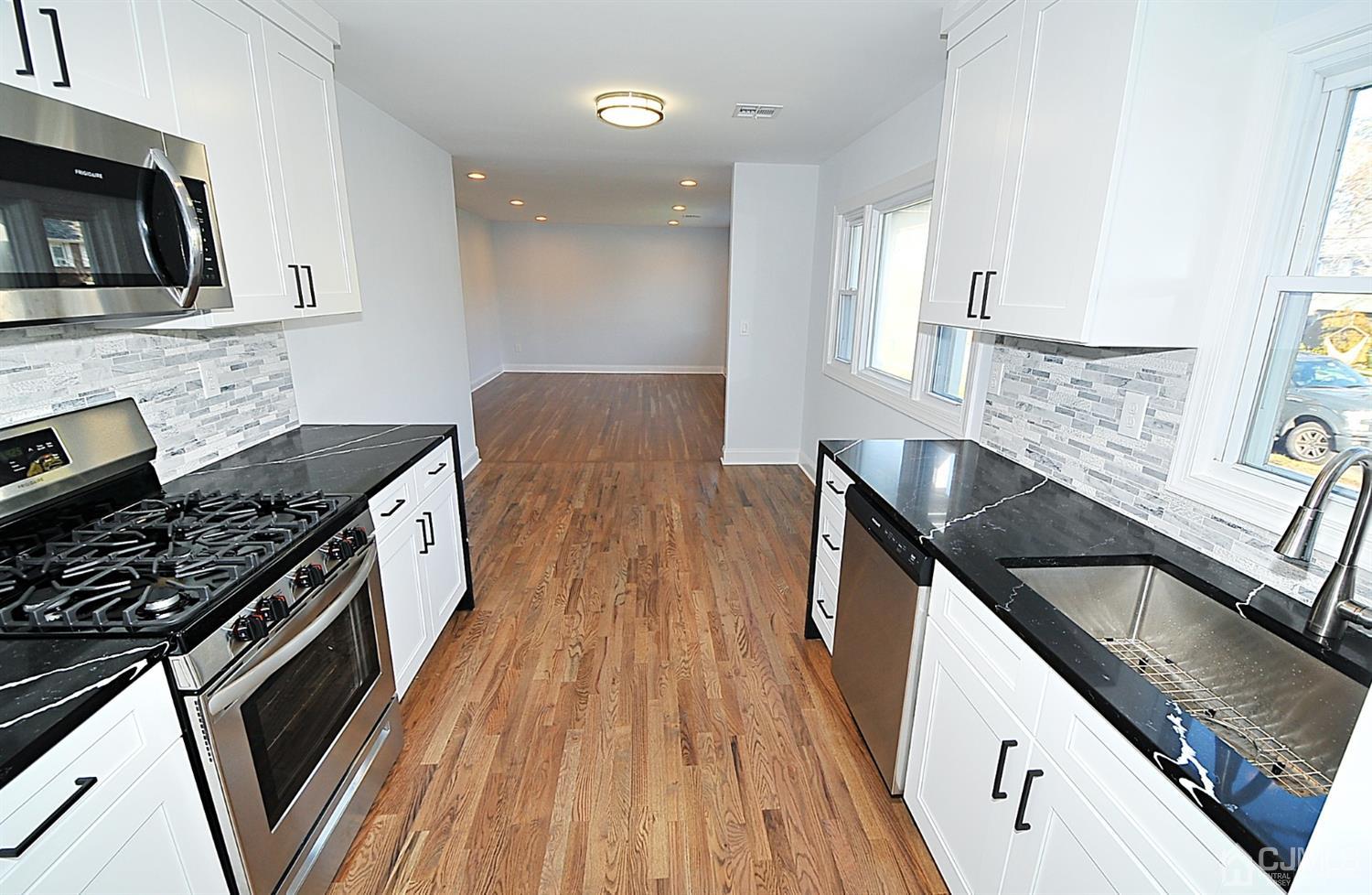 24 Prescott Street Edison, NJ 08817 - Photo 10 of 27 a kitchen with granite countertop a sink a stove oven and wooden floor