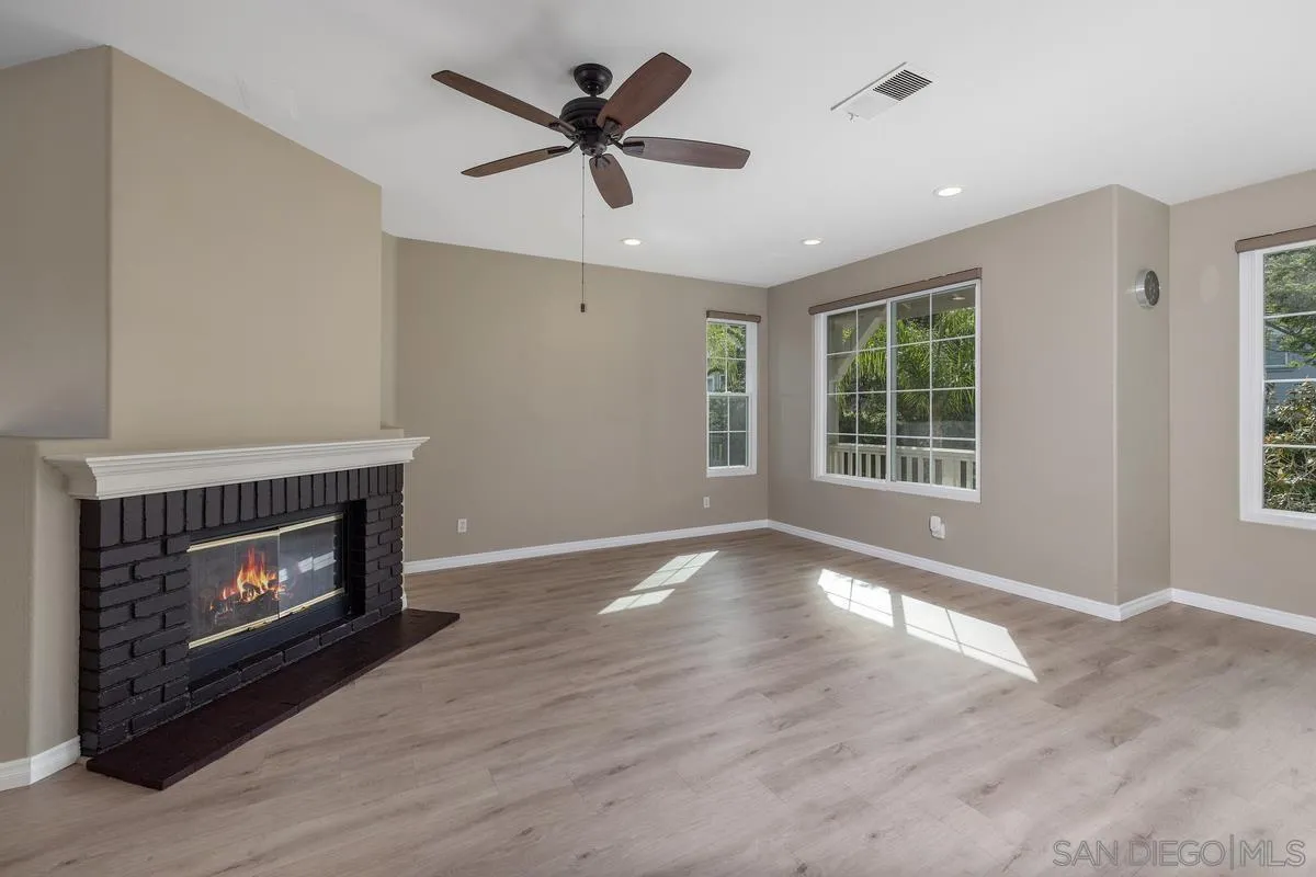 6013 Oakgate Row La Jolla, CA 92037 - Photo 15 of 50 a view of an empty room with wooden floor fireplace and a window