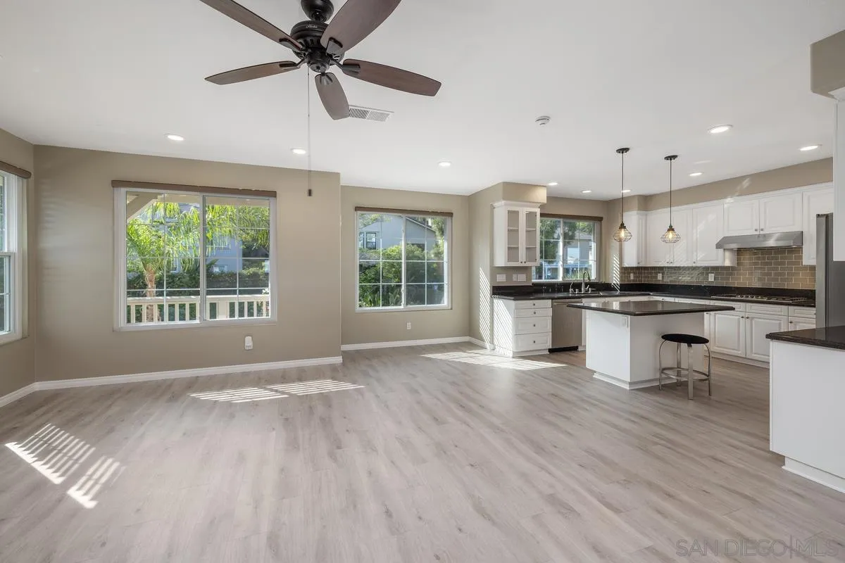 6013 Oakgate Row La Jolla, CA 92037 - Photo 16 of 50 a view of kitchen with stainless steel appliances granite countertop a stove top oven a sink dishwasher and a refrigerator with wooden floor
