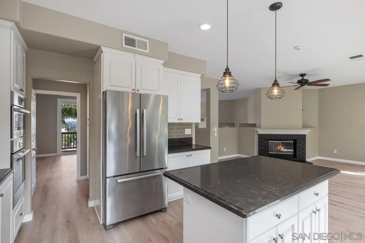 6013 Oakgate Row La Jolla, CA 92037 - Photo 19 of 50 a kitchen with kitchen island a counter top space stainless steel appliances and cabinets