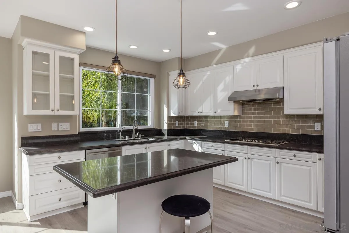 6013 Oakgate Row La Jolla, CA 92037 - Photo 2 of 50 a kitchen with a sink a counter space appliances and windows