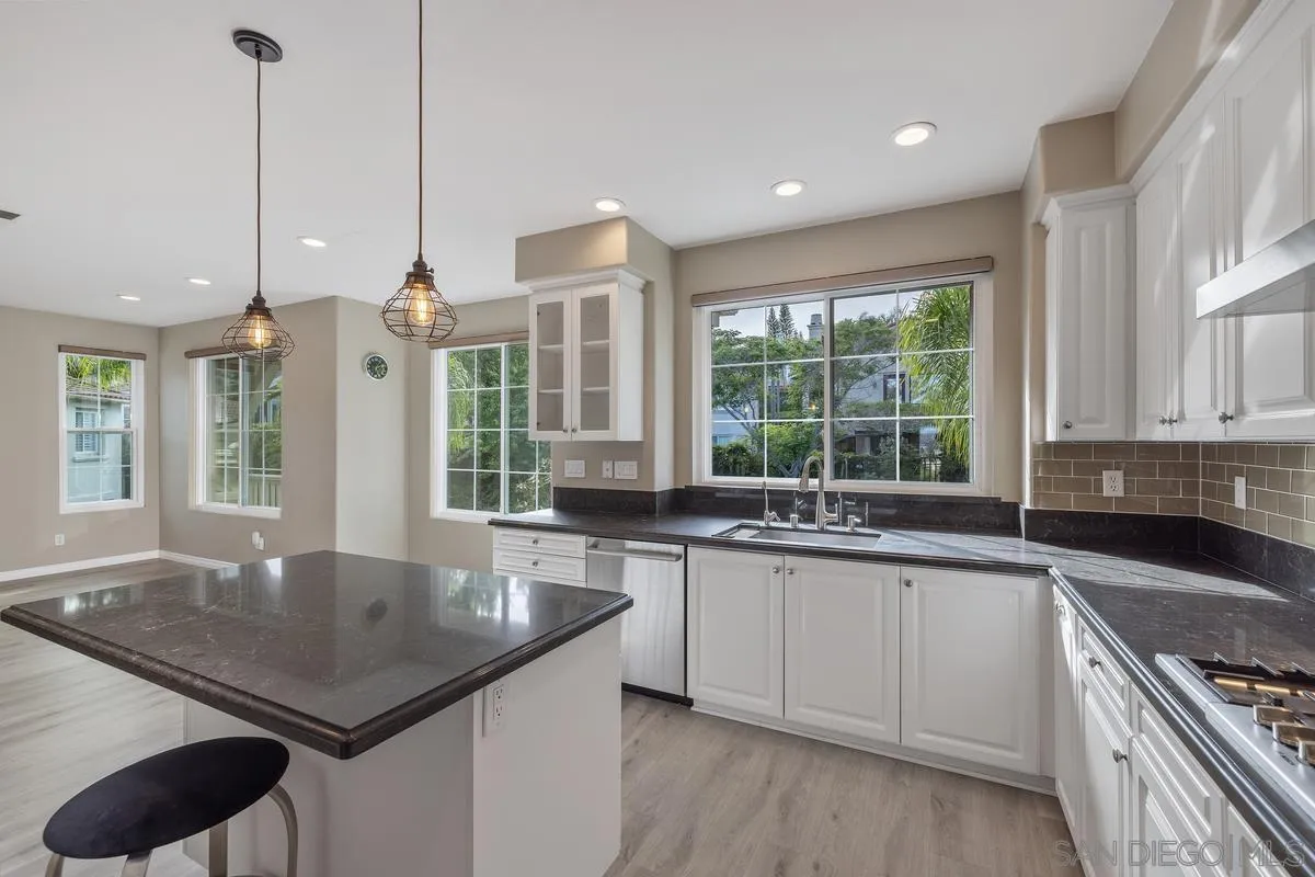 6013 Oakgate Row La Jolla, CA 92037 - Photo 21 of 50 a kitchen with a sink stove and cabinets