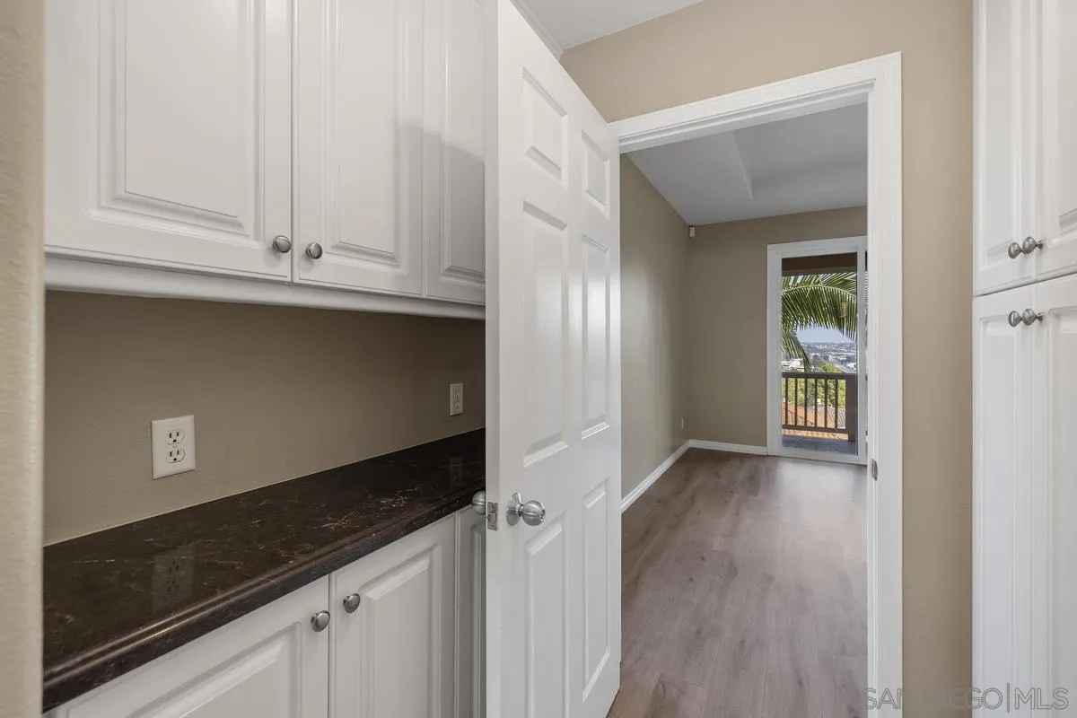 6013 Oakgate Row La Jolla, CA 92037 - Photo 22 of 50 a view of an empty room with wooden floor and cabinets