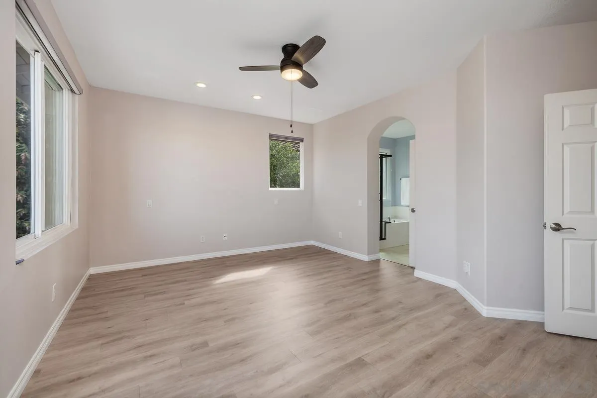 6013 Oakgate Row La Jolla, CA 92037 - Photo 28 of 50 an empty room with wooden floor and ceiling fan