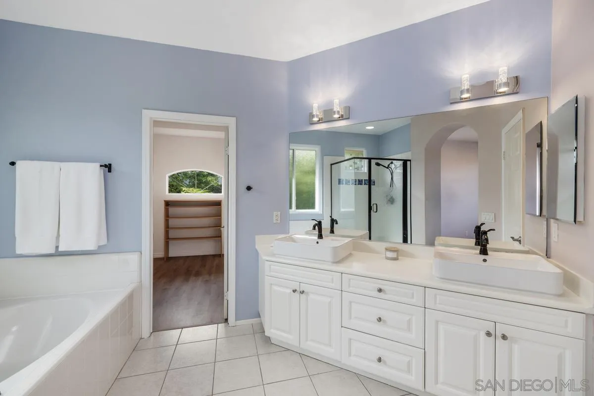 6013 Oakgate Row La Jolla, CA 92037 - Photo 29 of 50 a bathroom with a sink a tub and a mirror