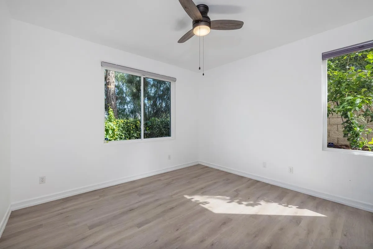 6013 Oakgate Row La Jolla, CA 92037 - Photo 35 of 50 an empty room with wooden floor and windows