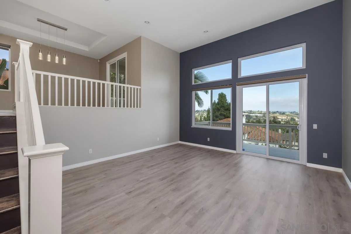 6013 Oakgate Row La Jolla, CA 92037 - Photo 7 of 50 a view of an empty room with wooden floor and a window
