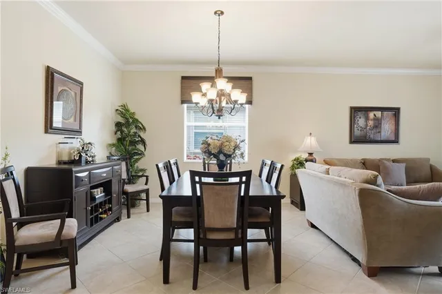 a dining room with furniture a chandelier and window