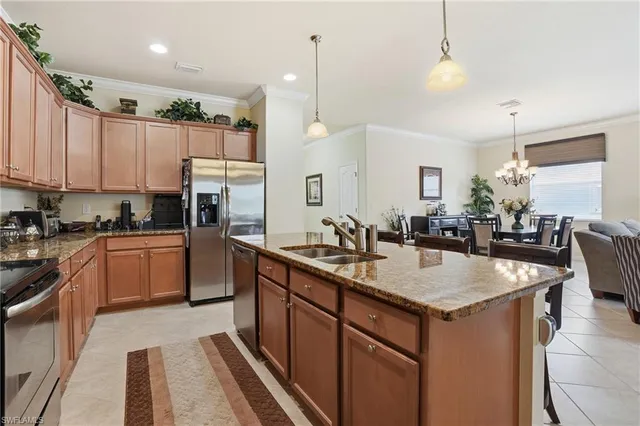 a kitchen with kitchen island granite countertop a sink a counter top space appliances and cabinets
