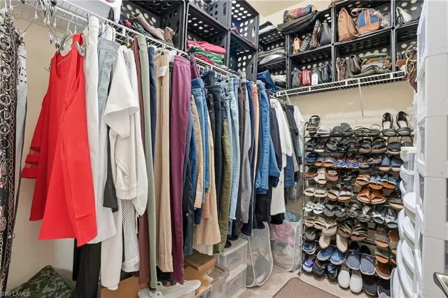 a view of walk in closet with clothes and shoes