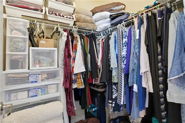 a view of walk in closet with clothes and shoes