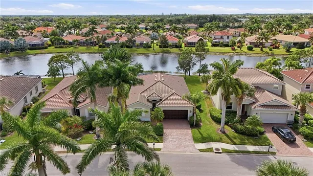 an aerial view of residential houses with outdoor space and lake view