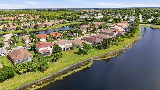 an aerial view of a city with lots of residential buildings ocean and mountain view in back