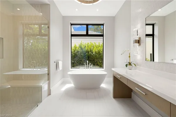 a bathroom with a tub sink and mirror