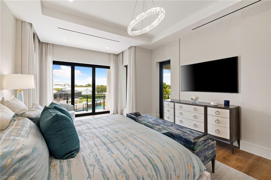 2345 Tarpon Road Naples, FL 34102 - Photo 29 of 43 a bedroom with a bed and a flat screen tv on dresser