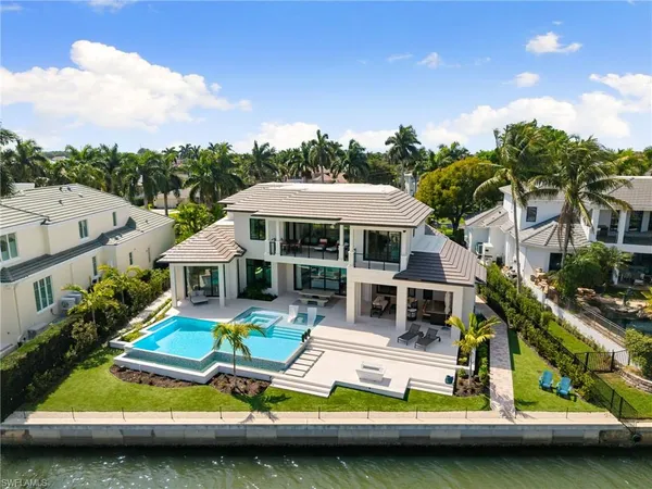 a view of swimming pool with lawn chairs under an umbrella