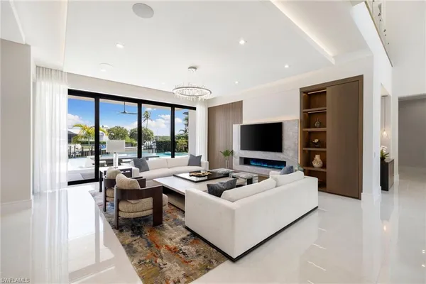 a living room with furniture flat screen tv and a large window
