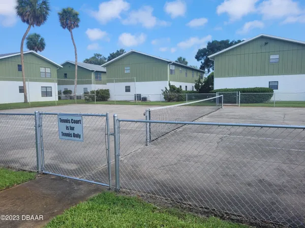 a view of a house with a yard and large parking space