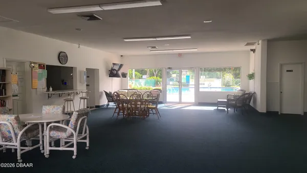 a dining room with furniture and a flat screen tv