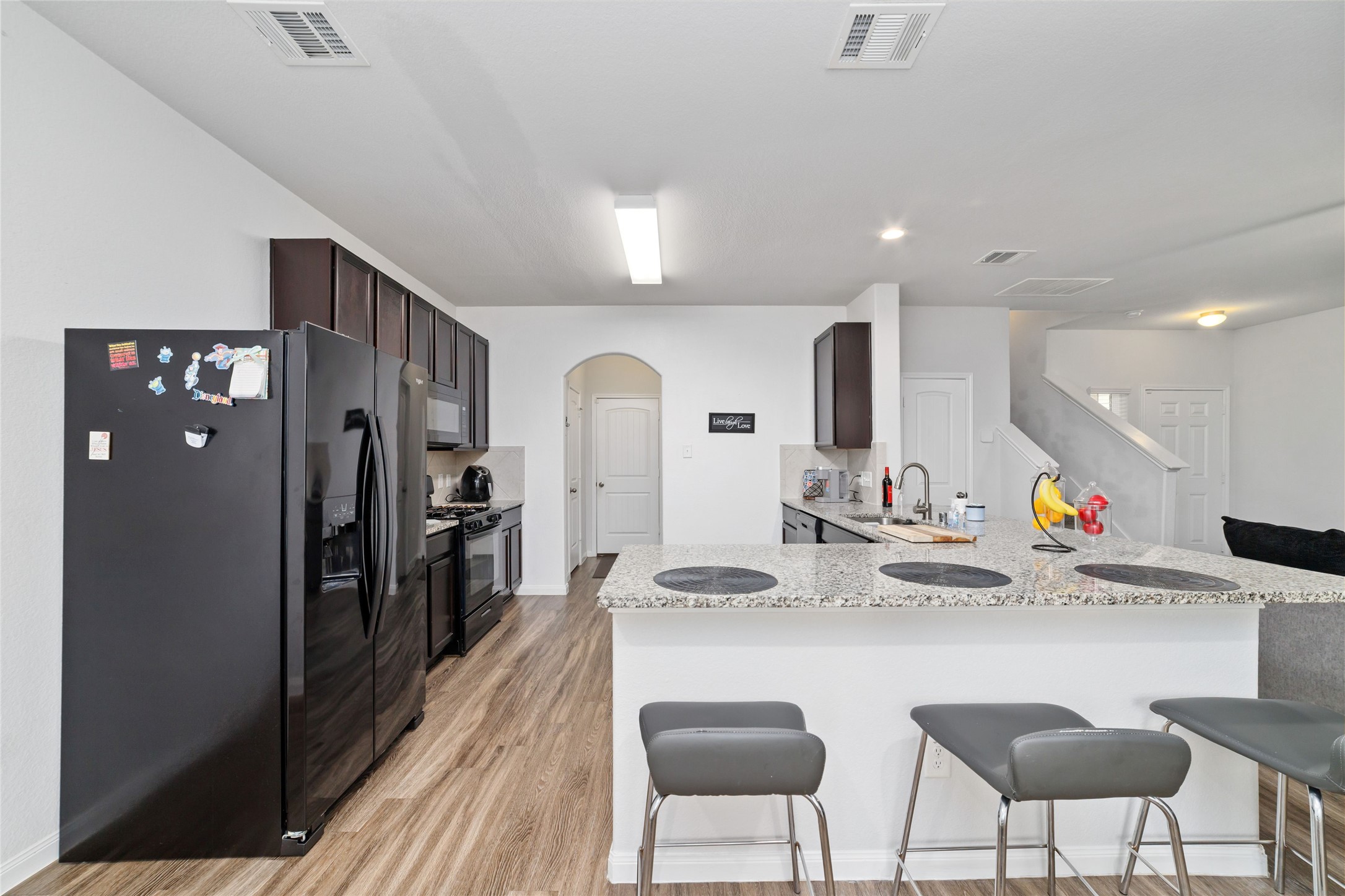 18619 Cooper Ravine Way Katy, TX 77449 - Photo 12 of 23 a kitchen with stainless steel appliances kitchen island granite countertop a refrigerator and a sink