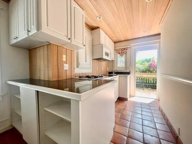 a kitchen with granite countertop a stove a sink and a refrigerator