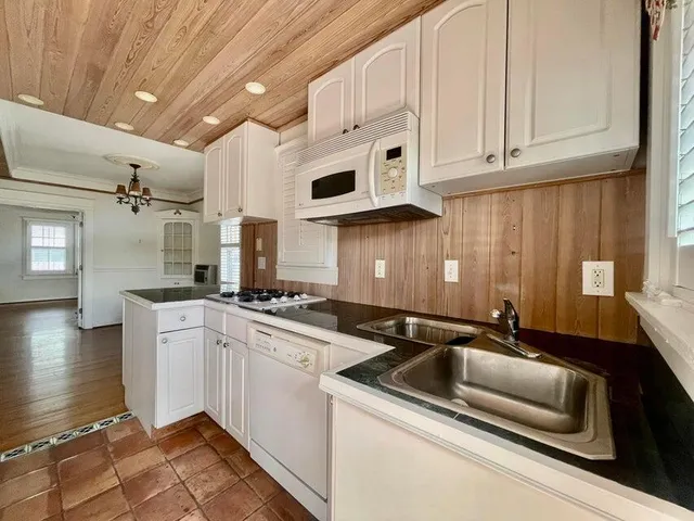 a kitchen that has a sink and white cabinets