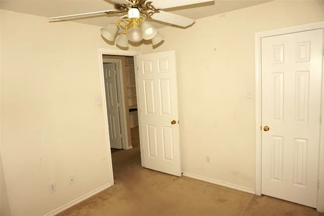 an empty room with a window and a ceiling fan
