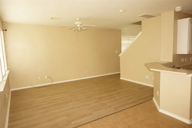 a view of a kitchen with white wooden cabinets and entryway