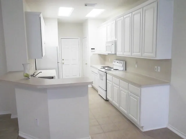 a kitchen with a sink a stove and a refrigerator
