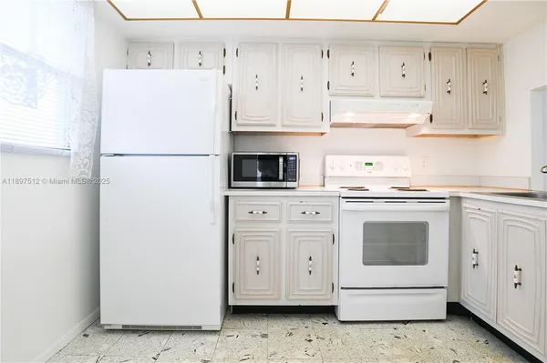 a kitchen with white cabinets and white appliances
