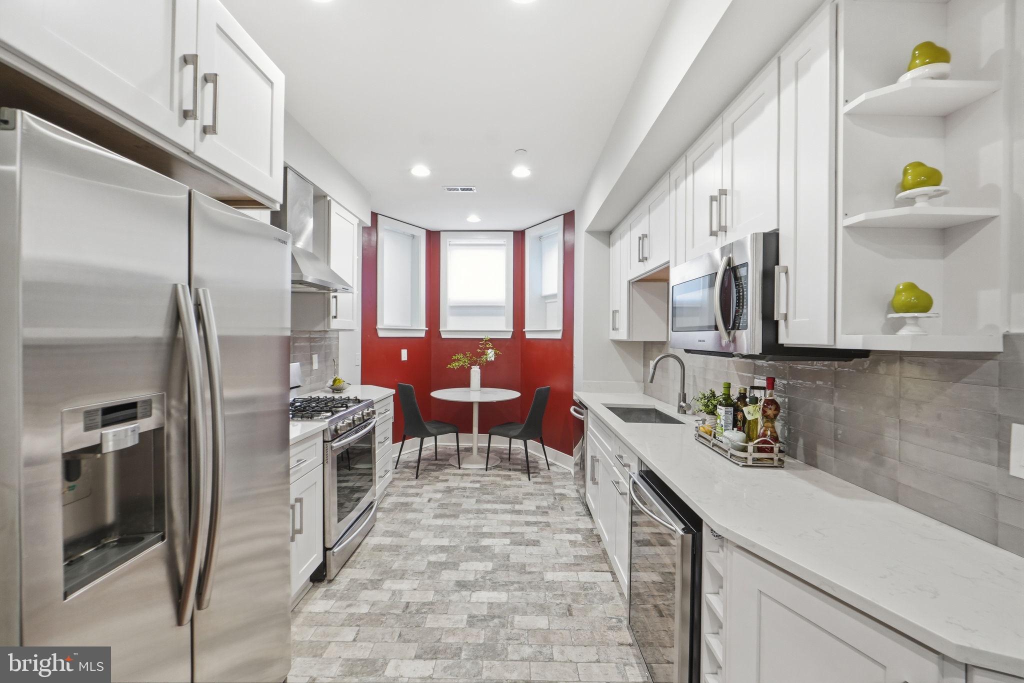 1126 5th Street Northwest, Unit 1 Washington, DC 20001 - Photo 11 of 27 a kitchen with stainless steel appliances kitchen island granite countertop a refrigerator and a sink