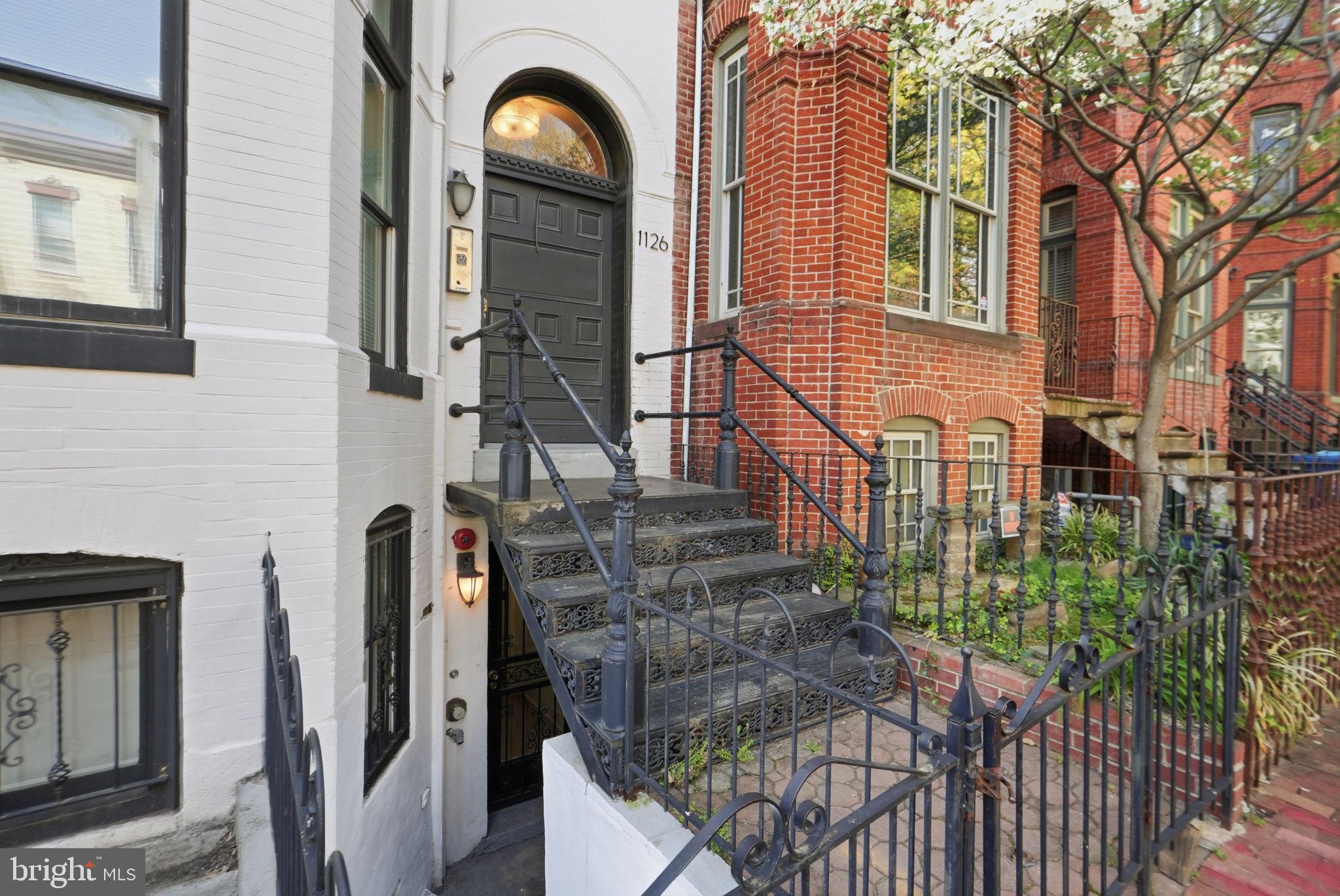 1126 5th Street Northwest, Unit 1 Washington, DC 20001 - Photo 3 of 27 a view of a brick house with large windows and a table and chairs