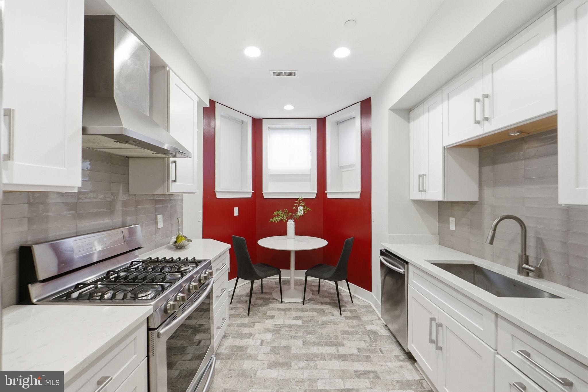 1126 5th Street Northwest, Unit 1 Washington, DC 20001 - Photo 10 of 27 a kitchen with a stove a sink cabinets and wooden floor