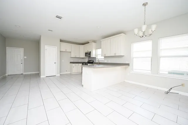 a kitchen with stainless steel appliances granite countertop a stove a sink and white cabinets