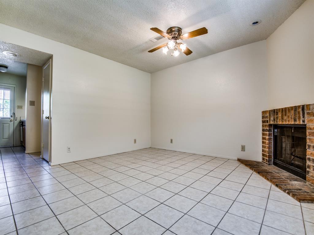 929 West Hickory Street, Unit A13 Denton, TX 76201 - Photo 2 of 12 an empty room with chandelier fan and windows