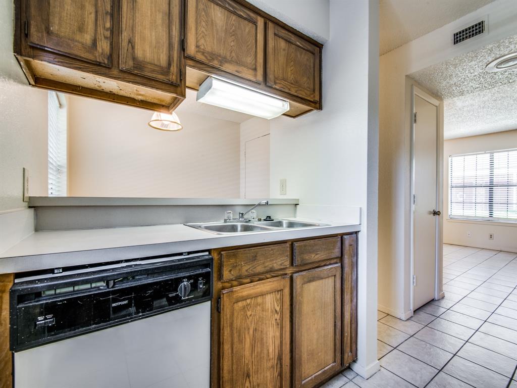 929 West Hickory Street, Unit A13 Denton, TX 76201 - Photo 6 of 12 a kitchen with stainless steel appliances granite countertop a stove and a microwave