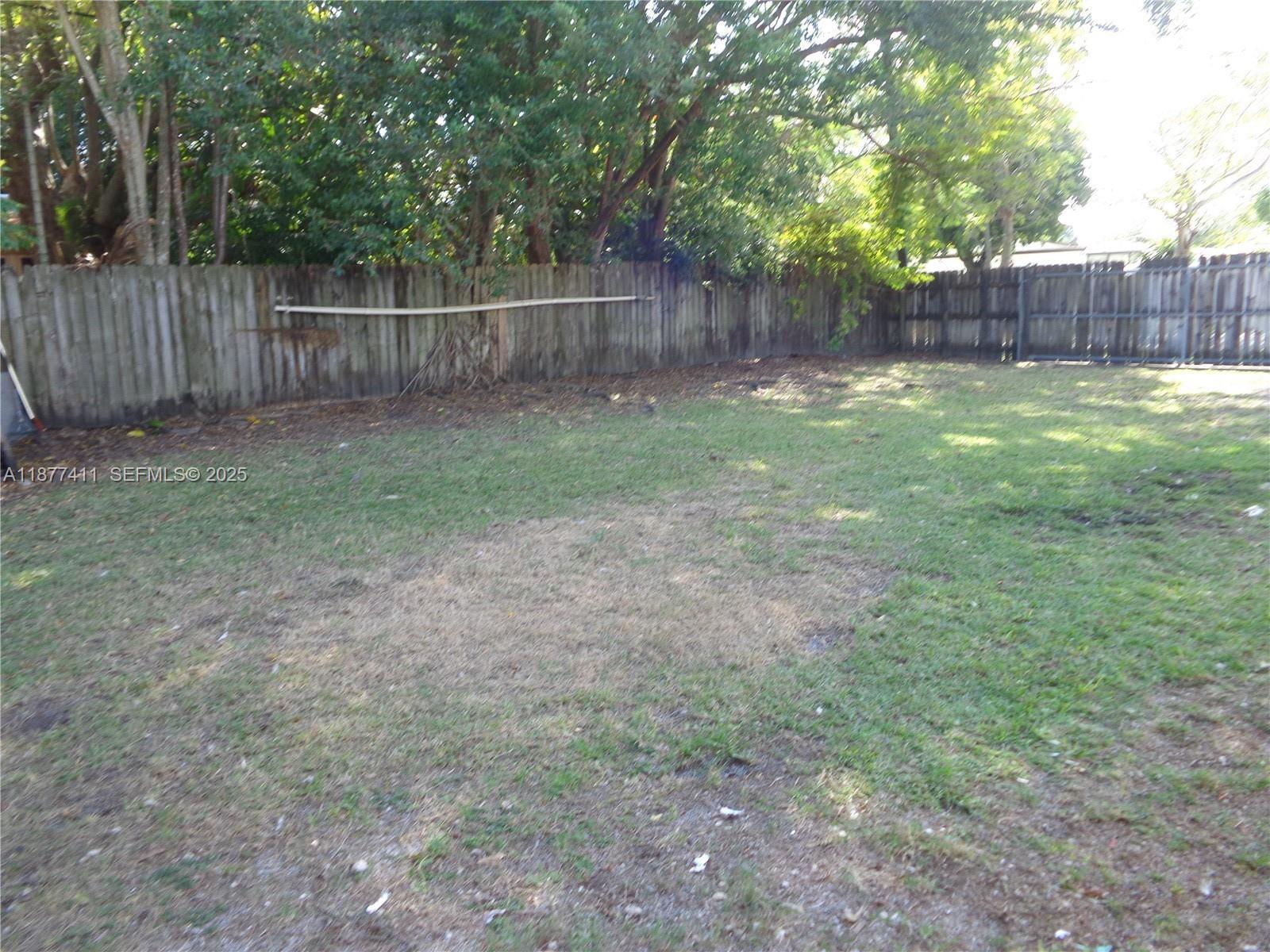 10020 Dominican Drive Cutler Bay, FL 33189 - Photo 21 of 22 a view of a backyard with a trees and wooden fence