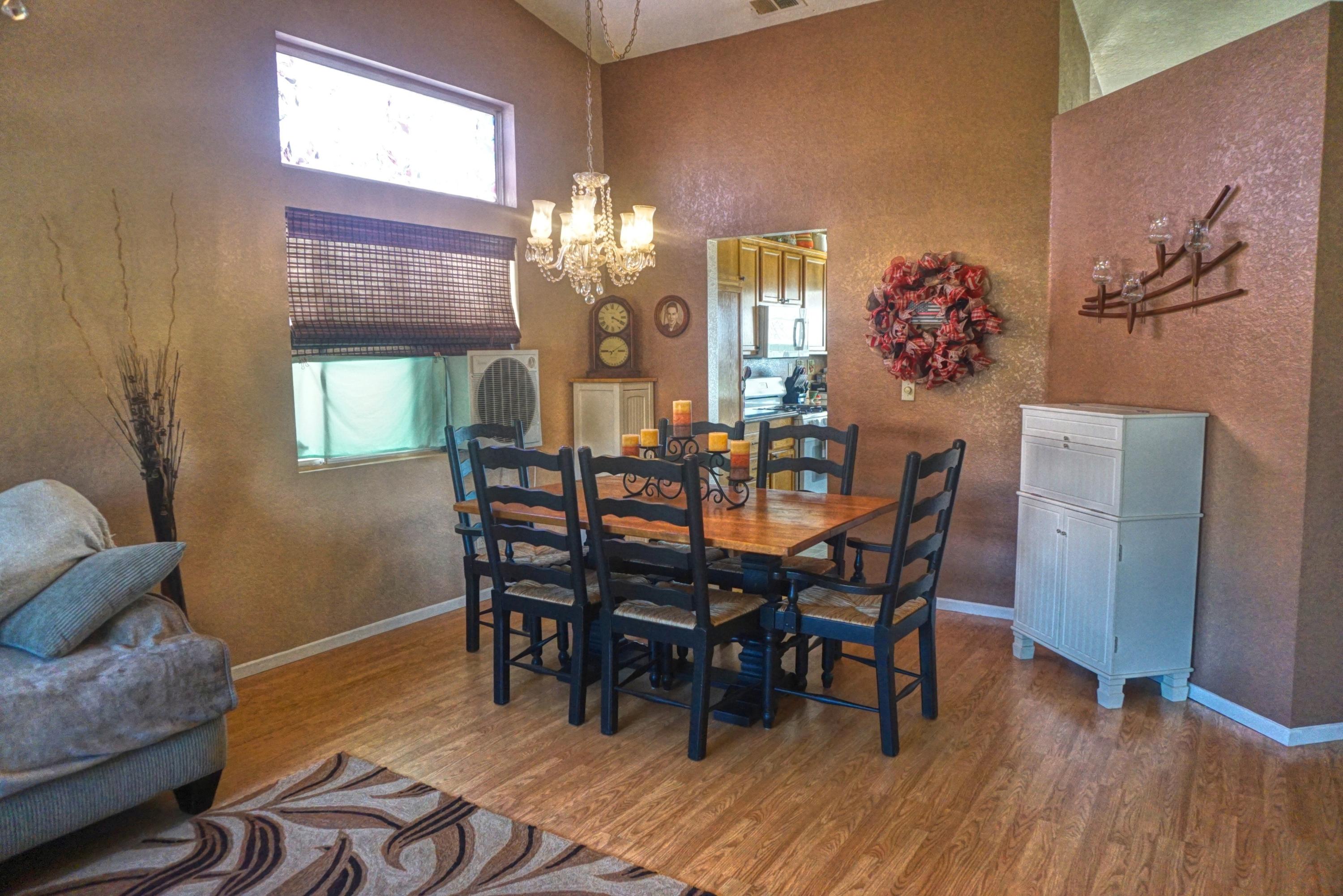 3165 Shale Road Palmdale, CA 93550 - Photo 3 of 23 a dining room with furniture a chandelier and wooden floor