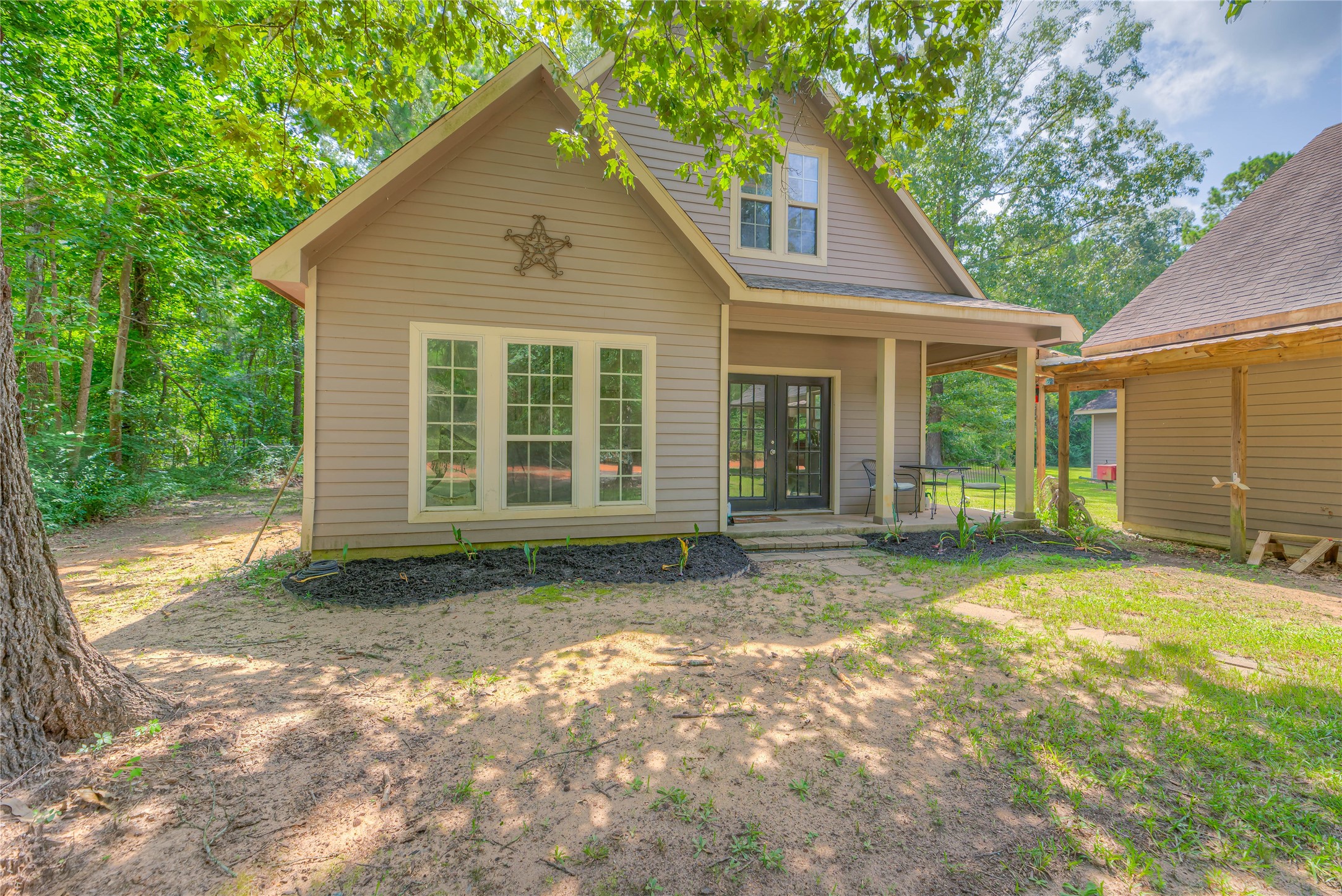 110 Happy Trails Road Coldspring, TX 77331 - Photo 19 of 49 a view of a yard in front of a house with large windows