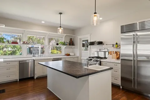 a kitchen with stainless steel appliances granite countertop a sink stove and refrigerator