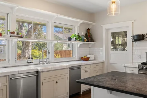 a kitchen with a sink a window and cabinets