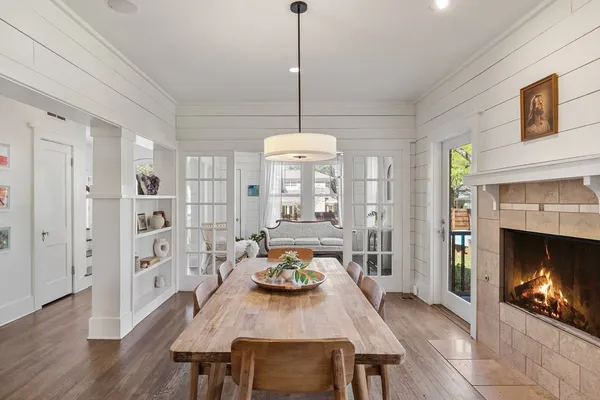 a dining room with furniture a fireplace and wooden floor