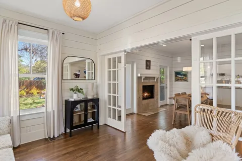 a view of a livingroom with furniture wooden floor windows and a fireplace
