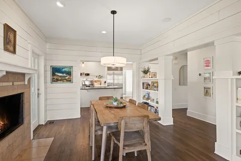 a dining room with furniture a floor to ceiling window and wooden floor