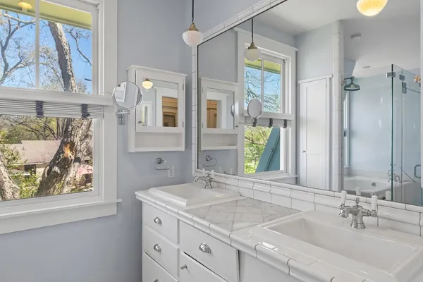 a bathroom with a granite countertop sink mirror and window