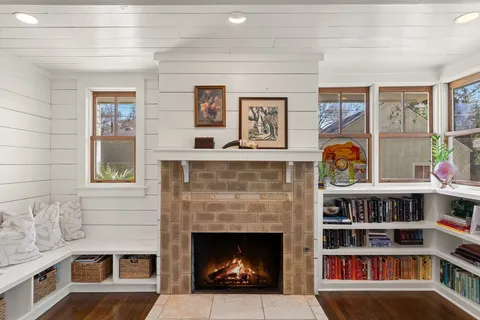 a living room with a fireplace and a book shelf
