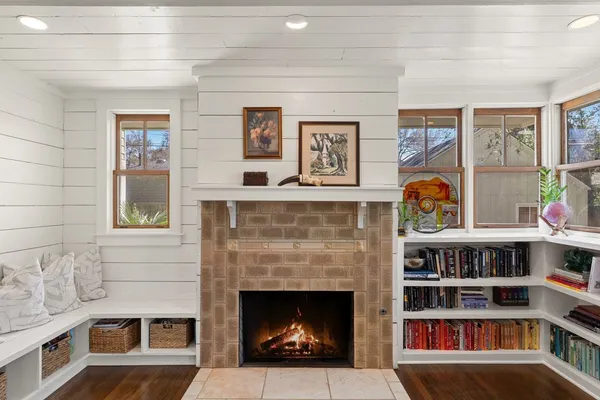 a living room with a fireplace and a book shelf