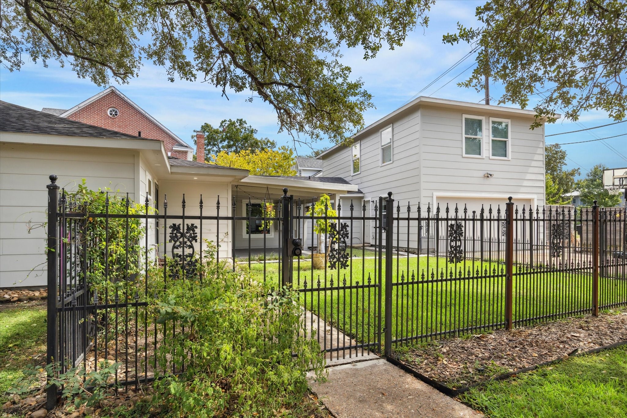 6047 Floyd Street Houston, TX 77007 - Photo 3 of 22 a view of a garden with a small yard and wooden fence