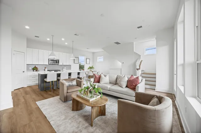 a living room with furniture and a view of kitchen