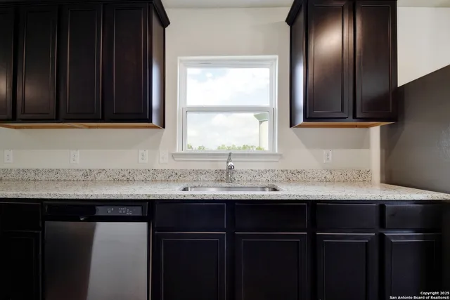 a kitchen with a sink a window and cabinets